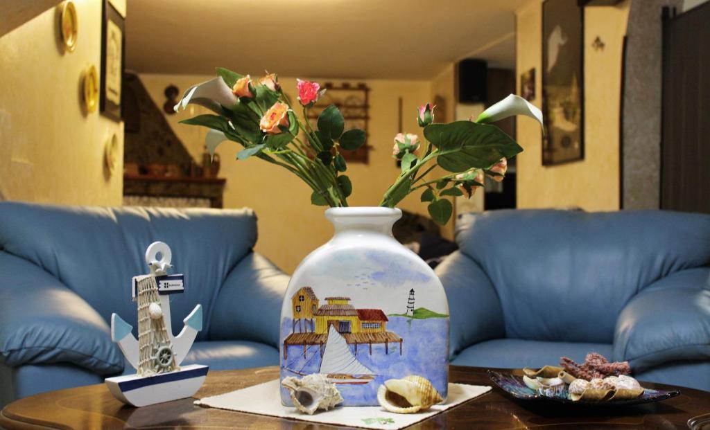 un vase avec des fleurs sur une table et des chaises dans l'établissement Sa Domu Frisca, à Domusnovas