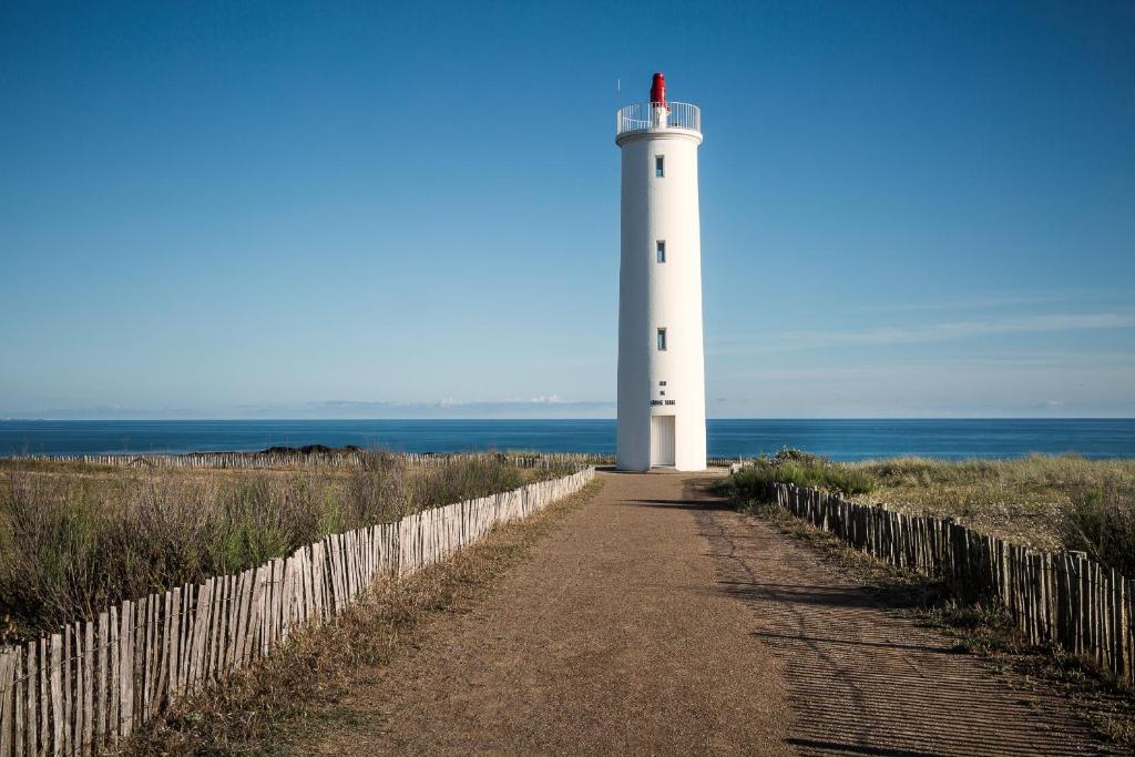- un phare sur la plage avec un chemin menant à celle-ci dans l'établissement Villa l'Atlantique, à Saint-Hilaire-de-Riez