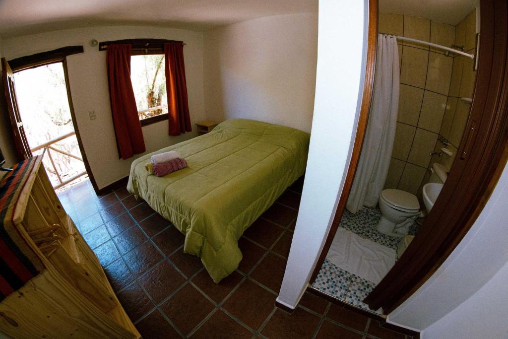 Habitación pequeña con cama y baño. en La Casa de Violeta en Tilcara