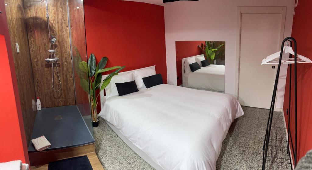a bedroom with a white bed and a red wall at Modern & Central 3 minutes from the River in Vila Nova de Gaia