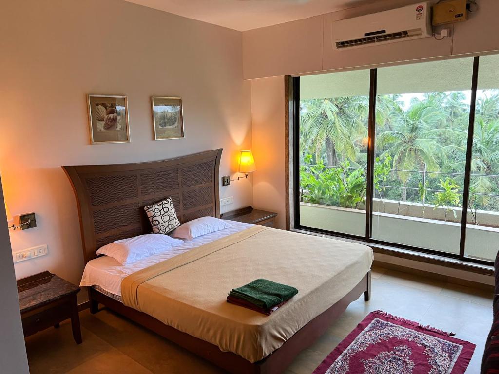 1 dormitorio con cama grande y ventana grande en Boloors sea la vie, en Suratakal