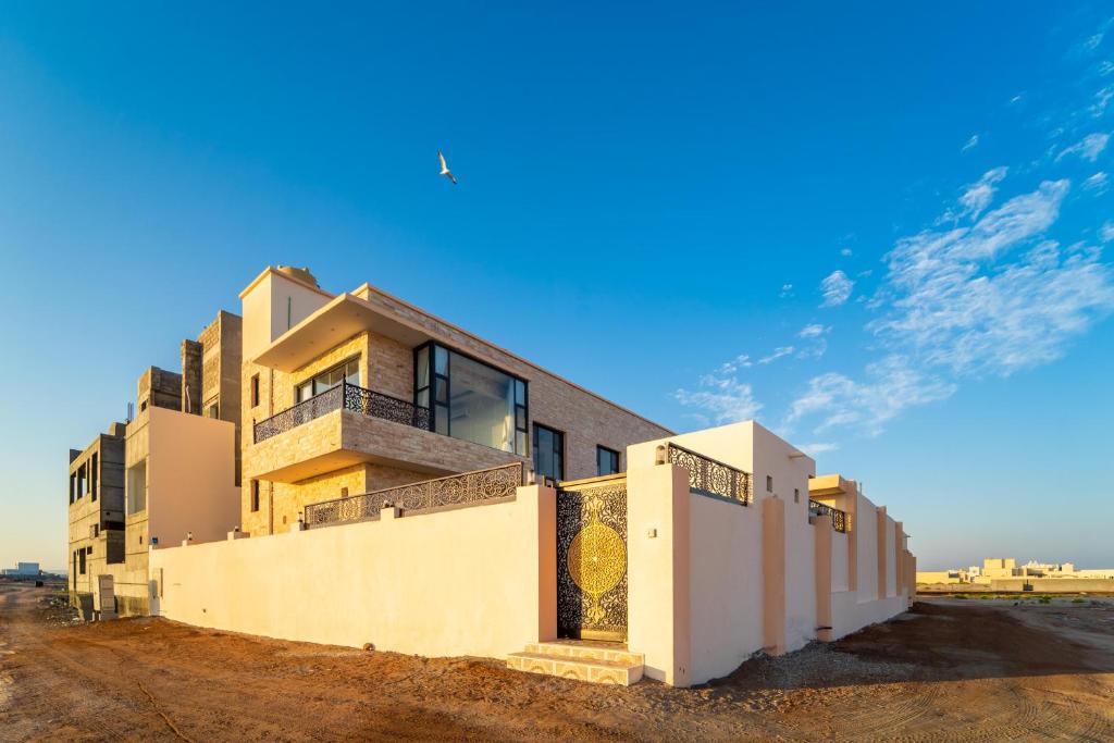 a building in the desert with a blue sky at COMFORT CHALET & APARTMENTS in Al Ḩadd