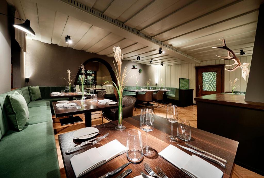 a dining room with a table and a green couch at Romantik Hotel Gasthaus Rottner in Nuremberg