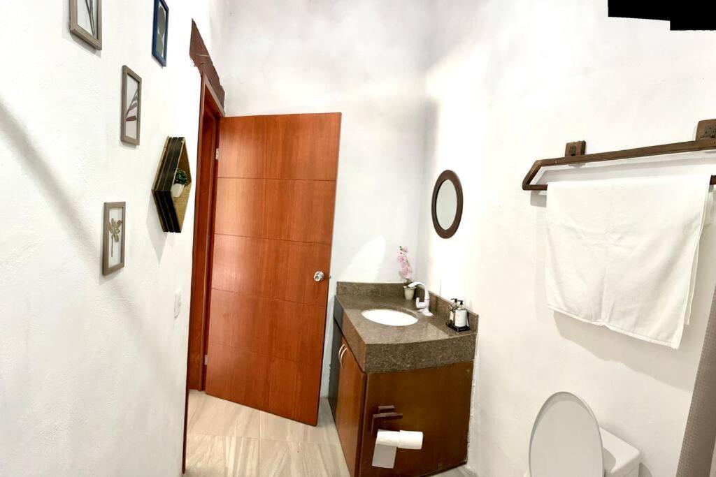 a bathroom with a sink and a wooden door at Casa el Capricho Cancún in Cancún
