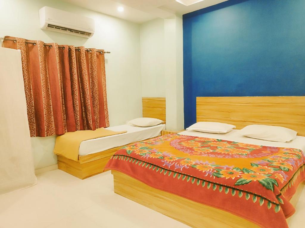 a bedroom with a bed and a blue wall at hotel Guru kripa - 500mtr app from Shreenathji temple in Nāthdwāra
