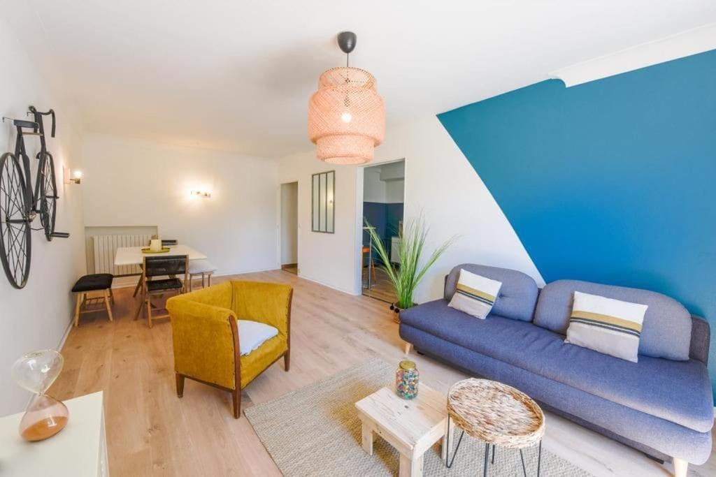 ein Wohnzimmer mit einem blauen Sofa und einem Tisch in der Unterkunft charmant logement plein pied au cœur du village in Castelculier