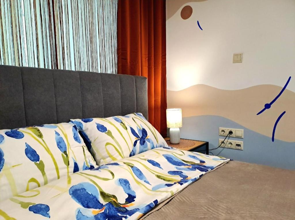 a bedroom with a bed with blue flowers on it at Студио Цвят/ Studio Colour in Blagoevgrad