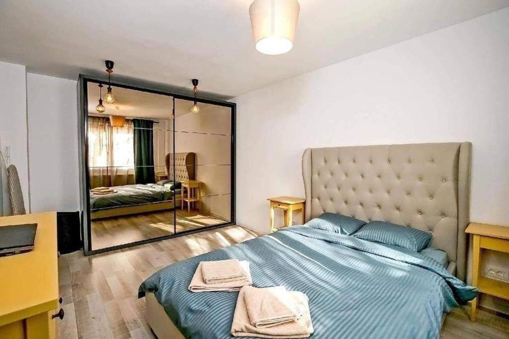 ein Schlafzimmer mit einem großen Bett und einem großen Spiegel in der Unterkunft Poetry I Piata Victorei in Bukarest
