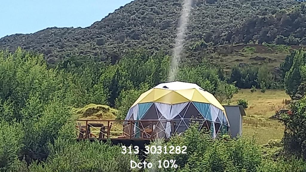 una cúpula geodésica con una fuente en un campo en Glamping Altos de Quiluva, en Suesca