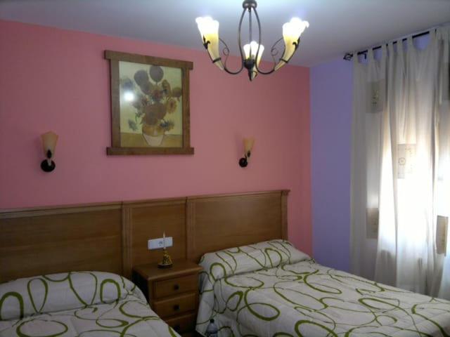 Una cama o camas en una habitación de Alojamiento por Habitaciones