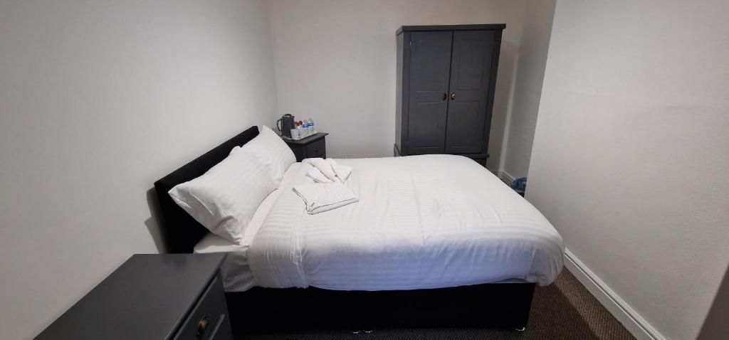 Dormitorio pequeño con cama con manta blanca en SELF CHECK IN APARTMENT DONCASTER en Doncaster