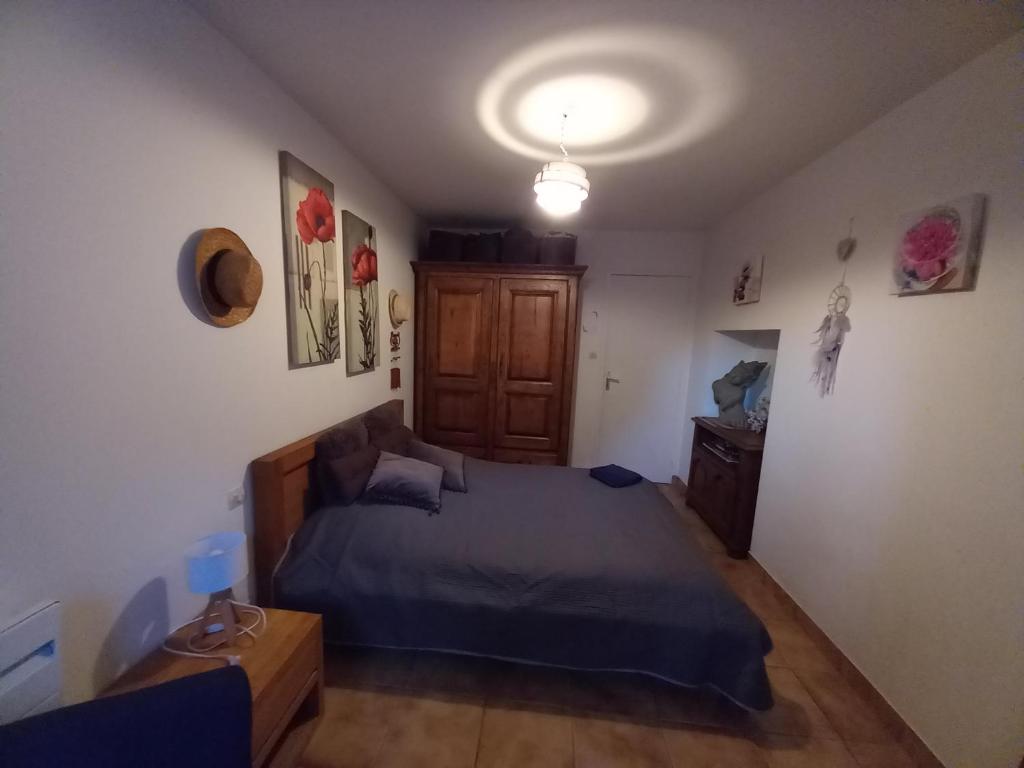 une chambre avec un lit et une armoire en bois dans l'établissement Maison d hote " chez marie " sur Paimpont, à Paimpont