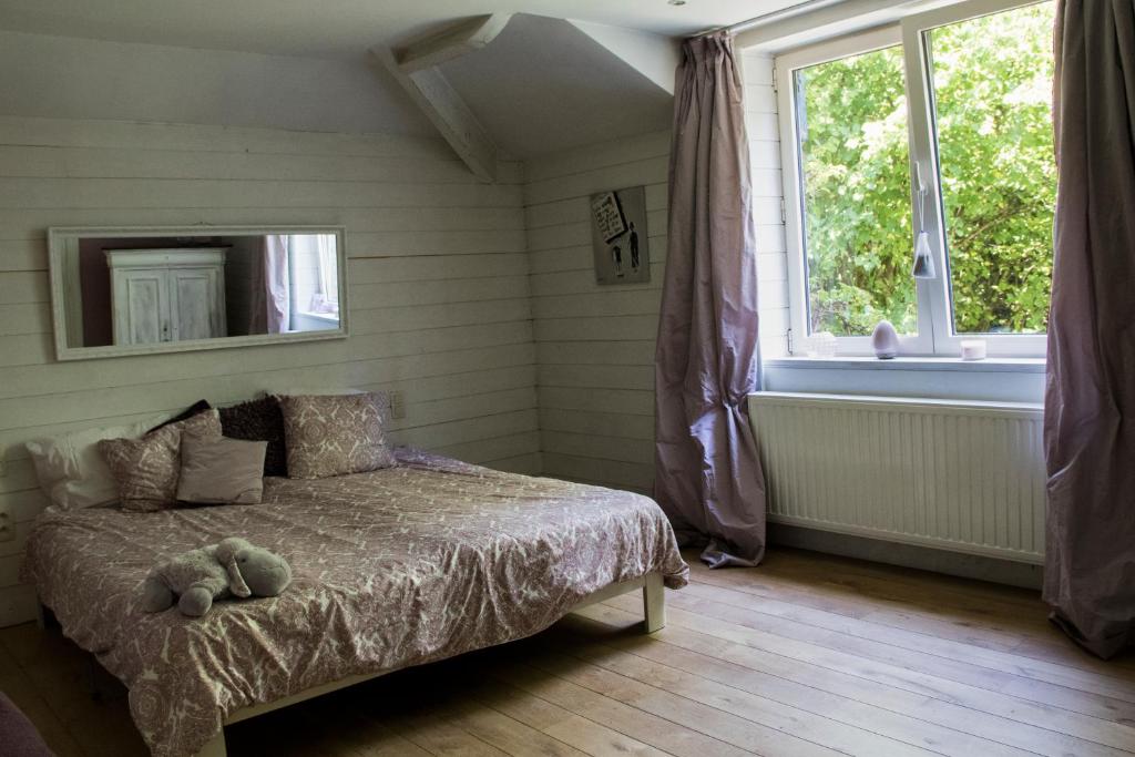 um quarto com uma cama com um urso de peluche em Villa Carpay em Louveigné
