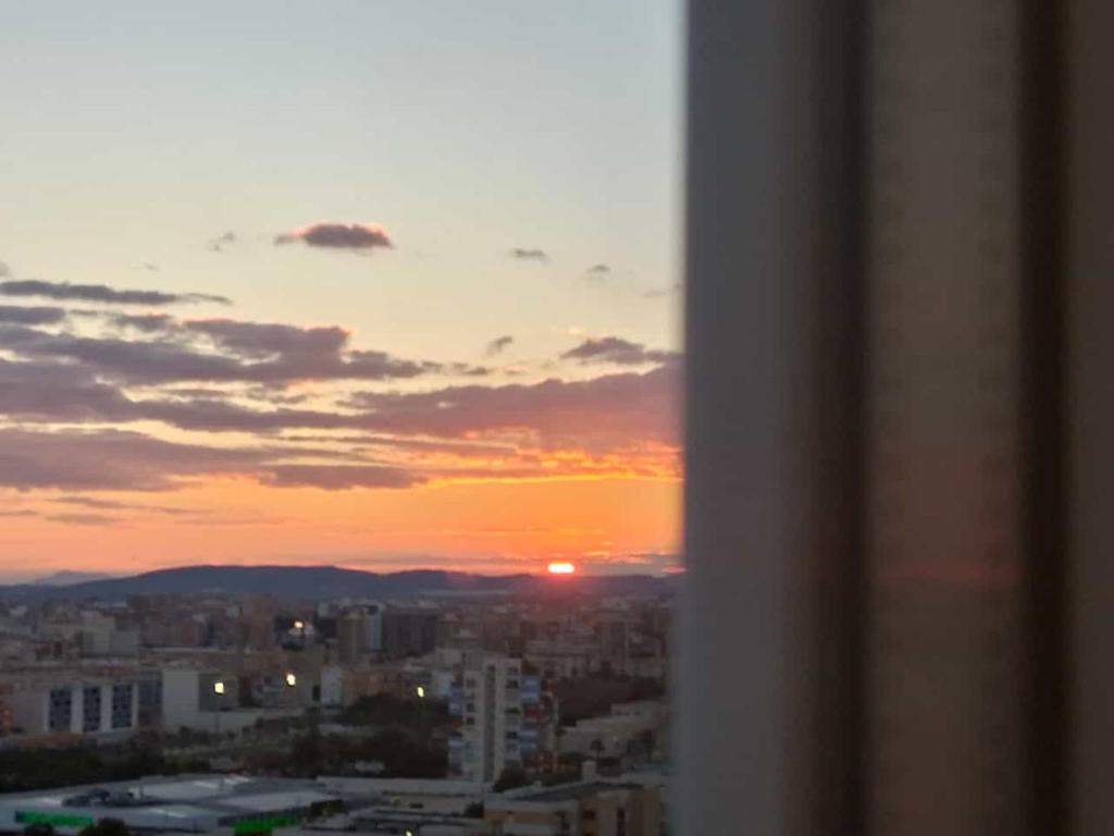 Blick auf den Sonnenuntergang von einer Stadt in der Unterkunft Éxito 888 in Alicante