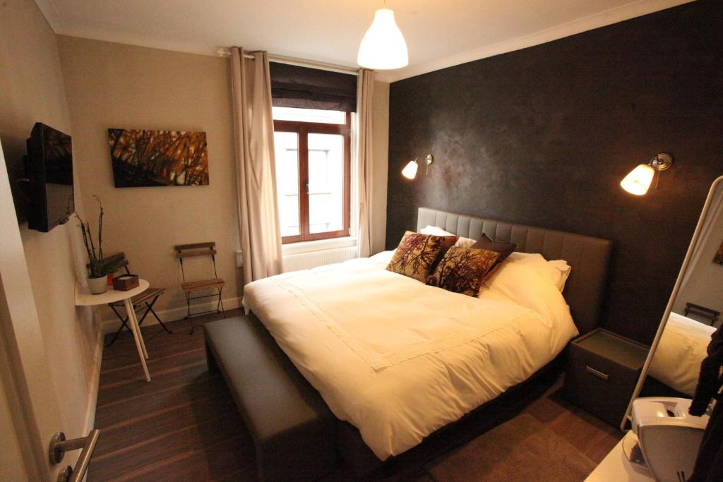una camera con un letto con una parete nera di B&B Sablon Antwerp ad Anversa