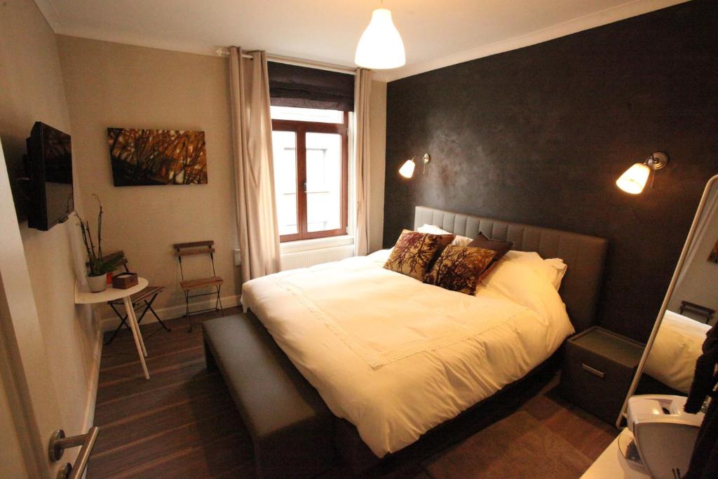 a bedroom with a bed with a black wall at B&B Sablon Antwerp in Antwerp