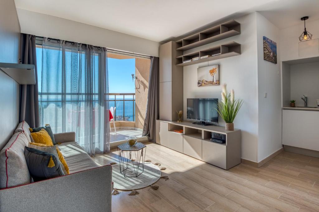 un soggiorno con divano e TV di Monaco Sea View & Parking a Beausoleil