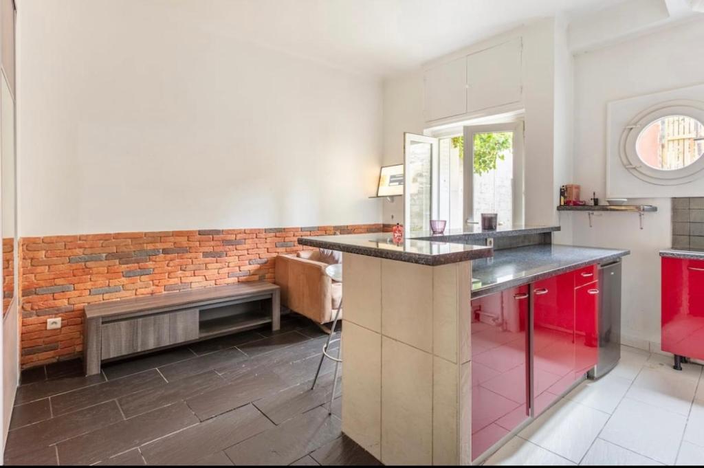 a kitchen with red cabinets and a bench in it at apartment with garden in Neuilly-sur-Seine