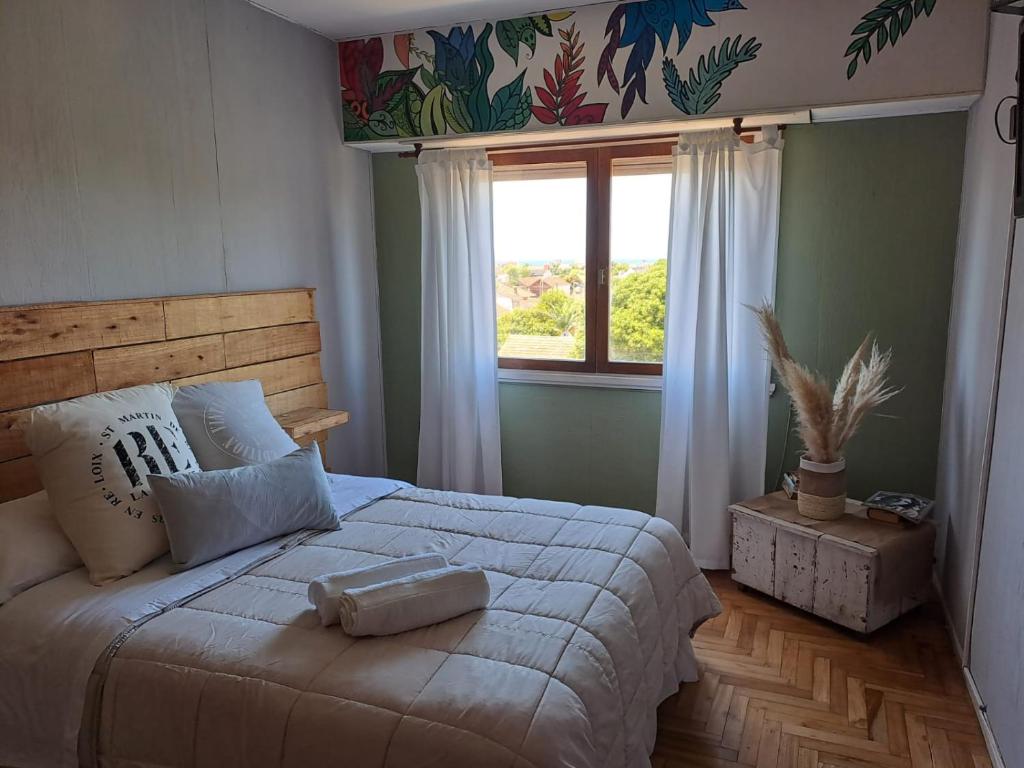 um quarto com uma cama grande e uma janela grande em Excelente DPTO a cuadras del mar em Mar del Plata