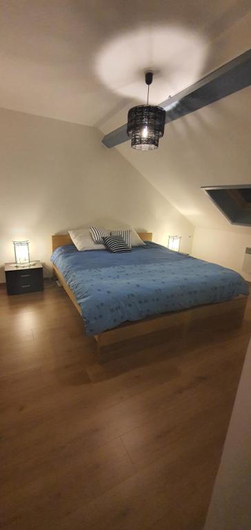 1 dormitorio con 1 cama con edredón azul en Le Petit Cocon, en Comines