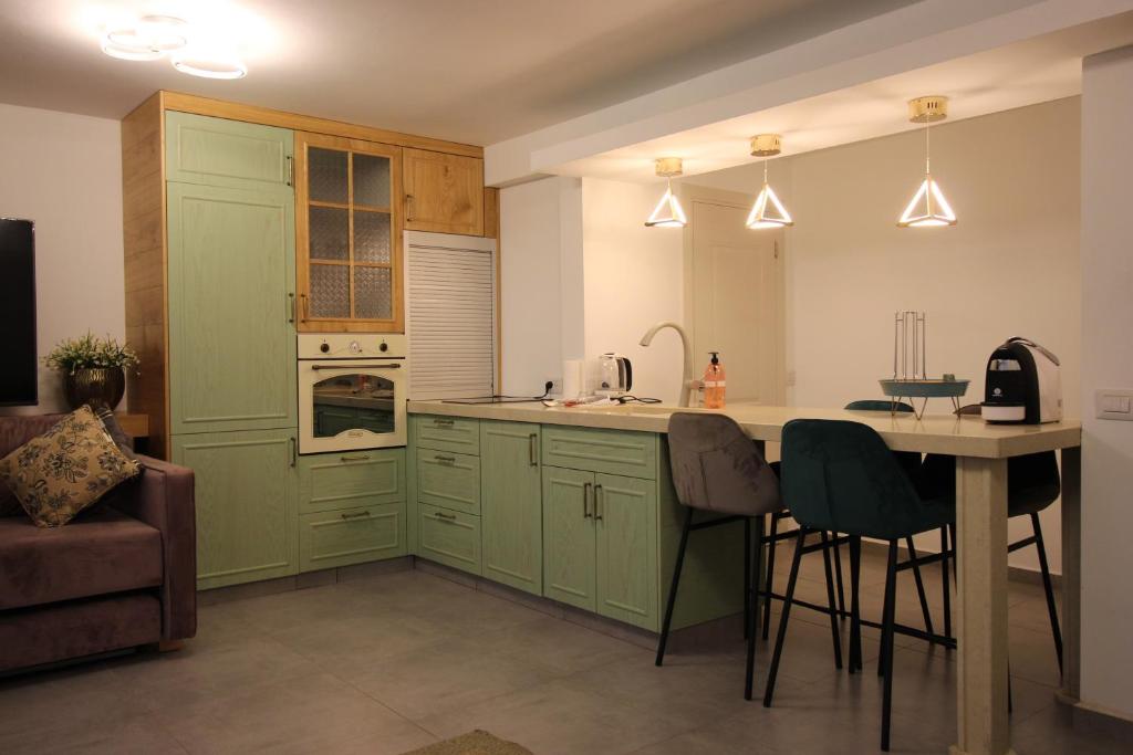 uma cozinha com armários verdes e uma mesa com cadeiras em סוויטות נופי החרמון - Hermon View Suites em Majdal Shams