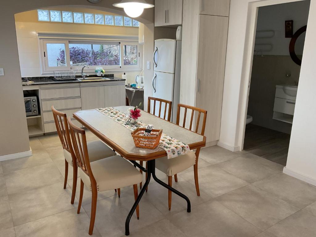 a kitchen with a table and chairs and a kitchen with a refrigerator at Los Zorzales in Villa Carlos Paz