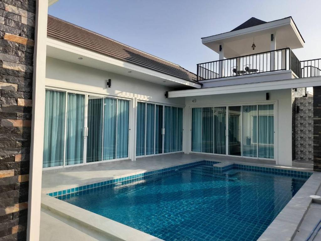 a swimming pool in front of a house at Dara pool villa in Ban Bang Liang