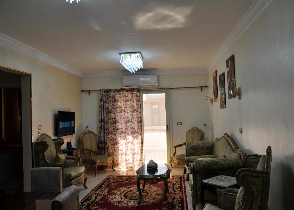 ein Wohnzimmer mit Stühlen und einem Fenster in der Unterkunft Mercy gardenia apartment-heliopolis new Cairo 518 Al Yasmin Zone,6th floor in Kairo