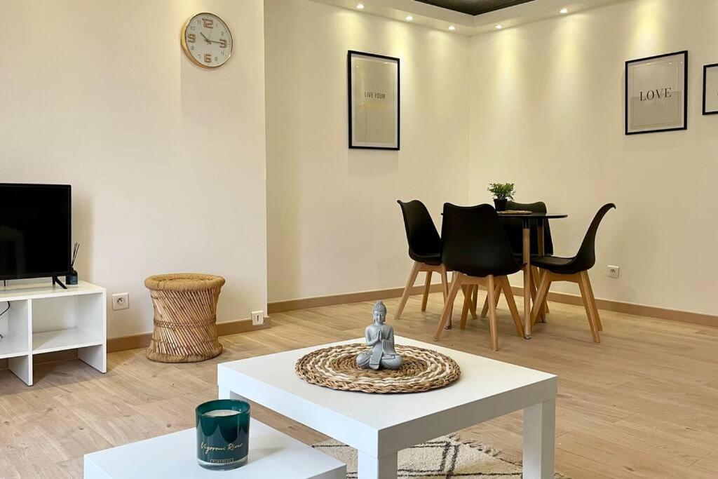 een woonkamer met een tafel en stoelen en een televisie bij Le Royal Cosy - Spacieux T2 - Proche Chantilly, Paris & Astérix in Nogent-sur-Oise