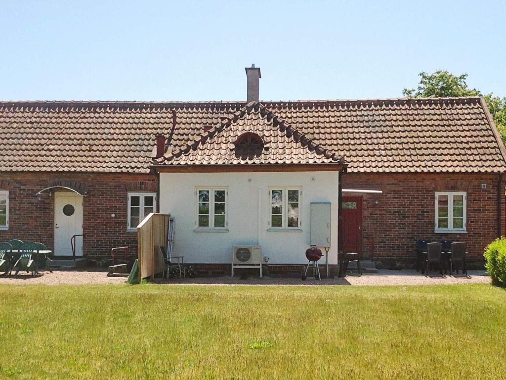 ein Backsteinhaus mit einem Tisch und Stühlen im Hof in der Unterkunft Holiday home YNGSJÖ, SVERIGE II in Yngsjö