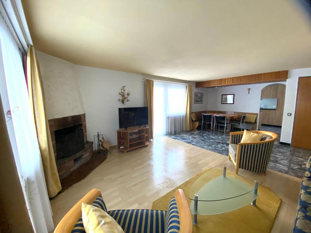 a living room with a table and a fireplace at Chalet Alm in Zermatt