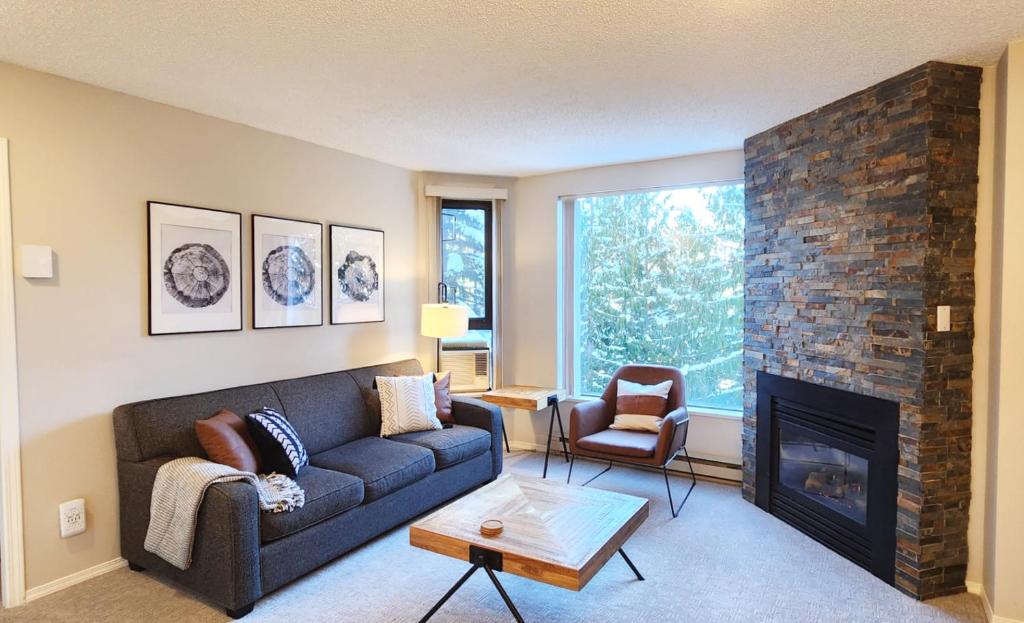 a living room with a couch and a fireplace at 1BR Ski In Ski Out Cozy Condo w Pool and Hot Tub by Harmony Whistler in Whistler