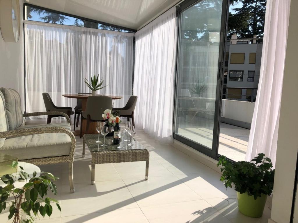 a living room with a table and chairs on a balcony at Appartement montfleury, 2 terrasses, 2 chambres , 2 sdb , pkg privé piscine, 15 min walk to Croisette beach and Palais des festivals in Cannes