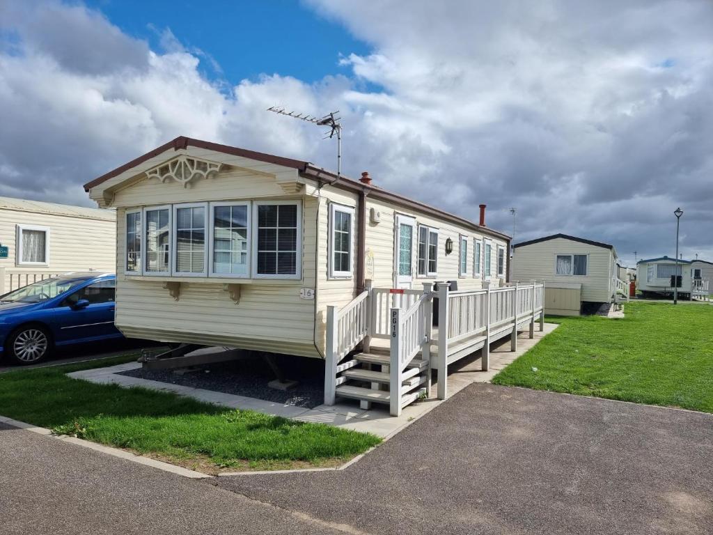 a tiny house is parked in a parking lot at palm grove 16 in Skegness
