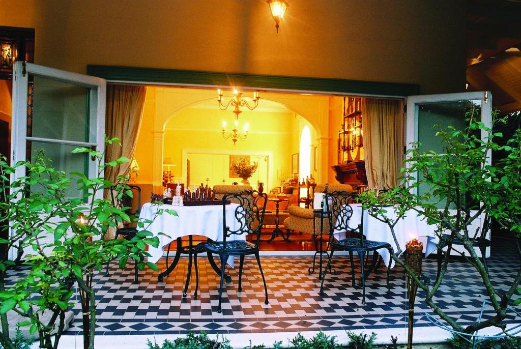 een kamer met een tafel en stoelen op een geruite vloer bij Hacklewood Hill Country House in Port Elizabeth