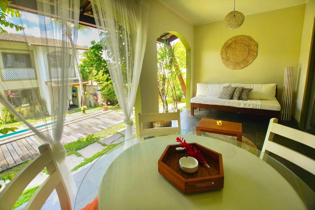a living room with a table and a couch at Flor da Mata in Pipa