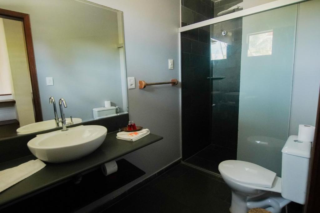 a bathroom with a sink and a toilet at Flor da Mata in Pipa