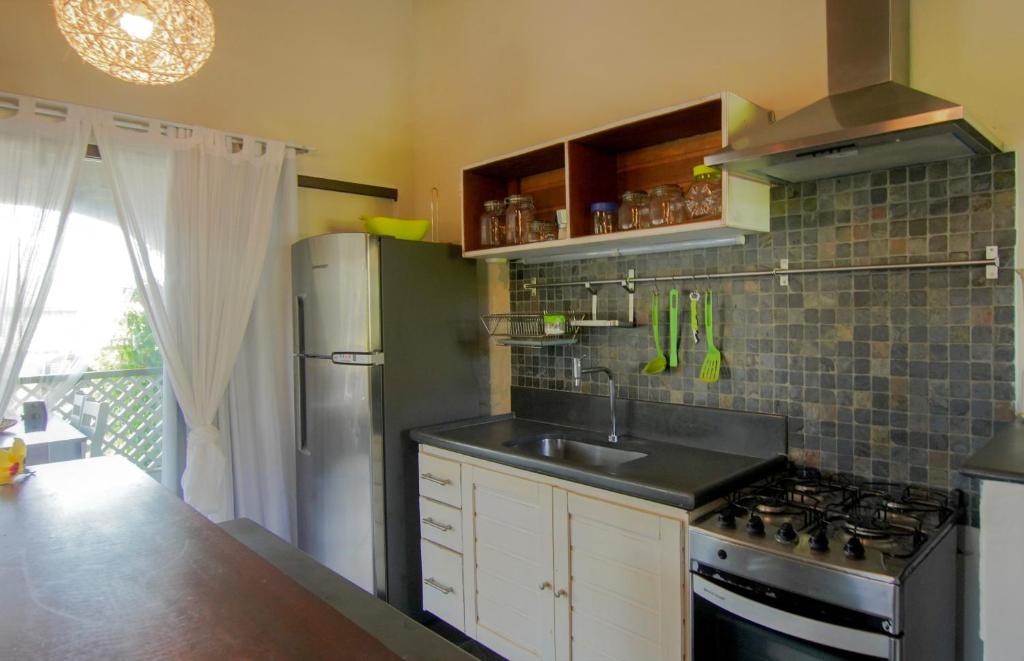 a kitchen with a sink and a stove at Flor da Mata in Pipa