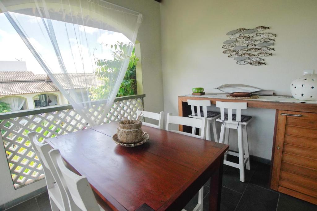 a kitchen with a wooden table and a balcony at Flor da Mata in Pipa