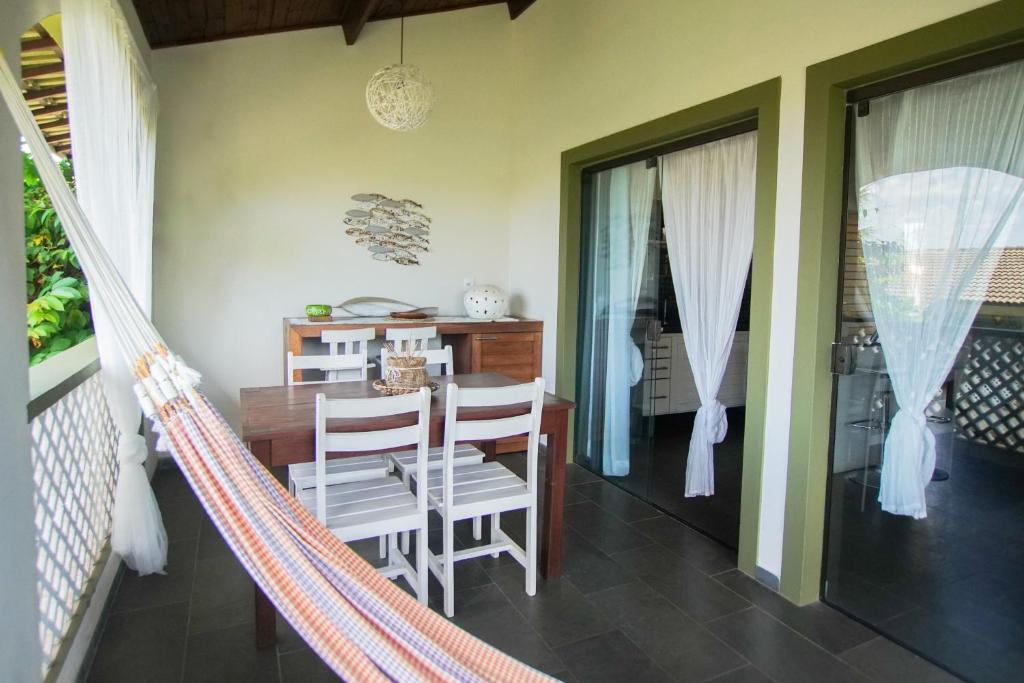 a hammock in a dining room with a table and chairs at Flor da Mata in Pipa