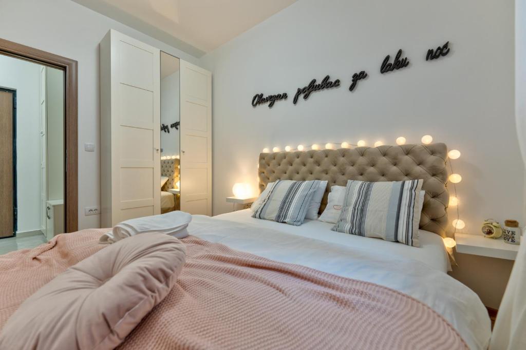 a bedroom with a large bed with lights on it at Dobro Mesto in Zlatibor