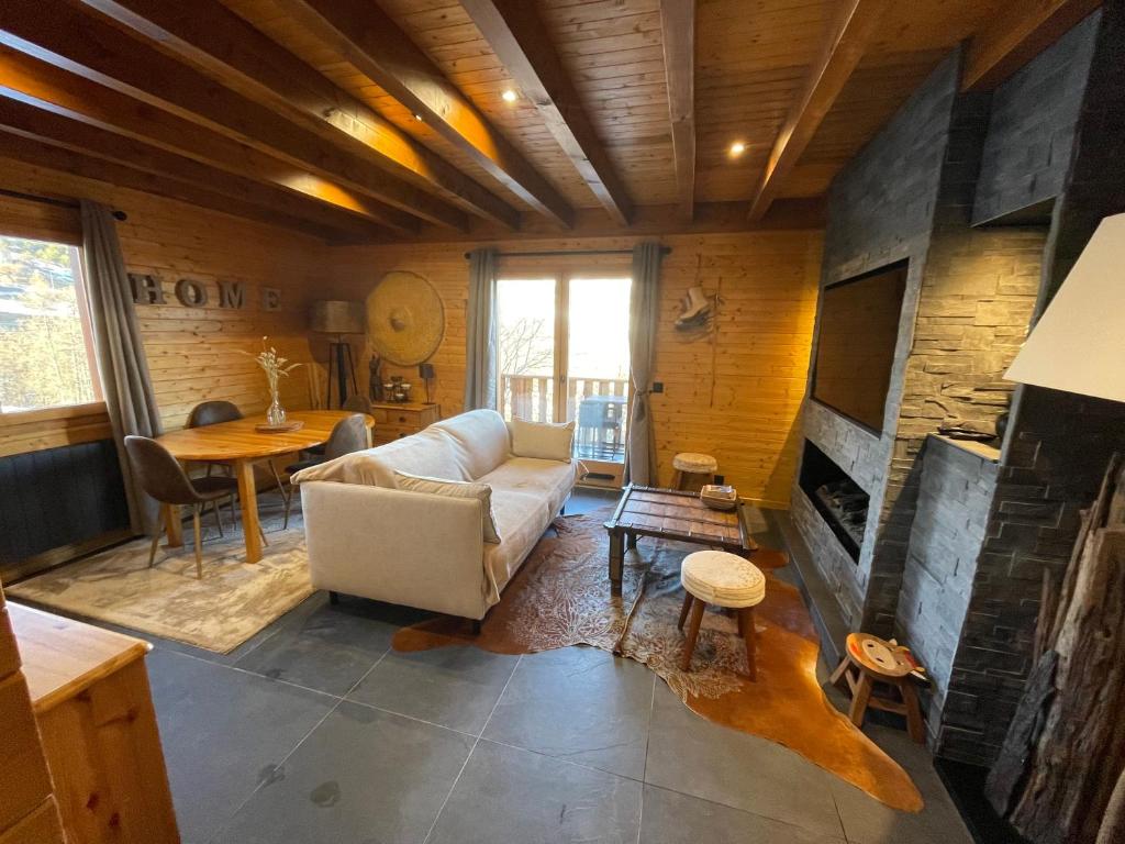 uma sala de estar com um sofá e uma lareira em Haut de Chalet L'entasse n°9 em Valberg