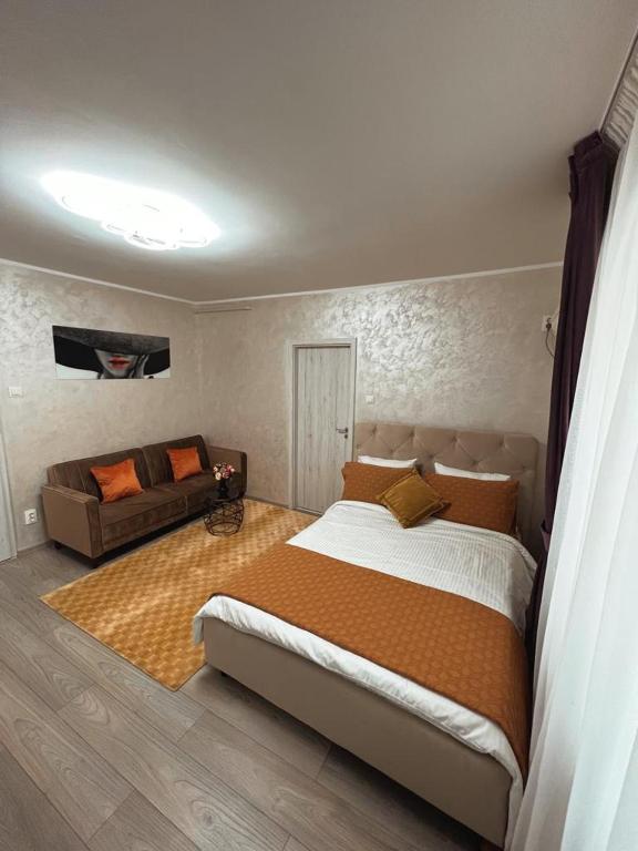 a bedroom with a large bed and a couch at Central Apartament in Iaşi