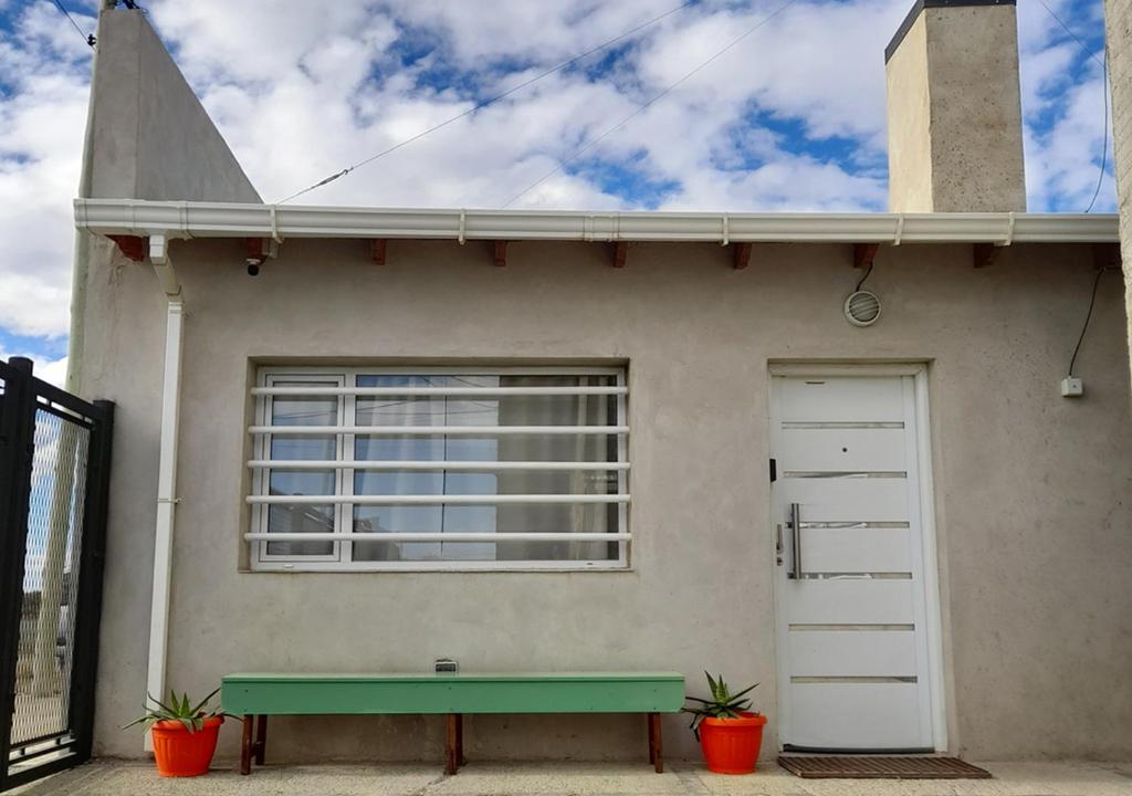 una casa con un banco verde delante de ella en Departamento full con estacionamiento privado en Río Gallegos