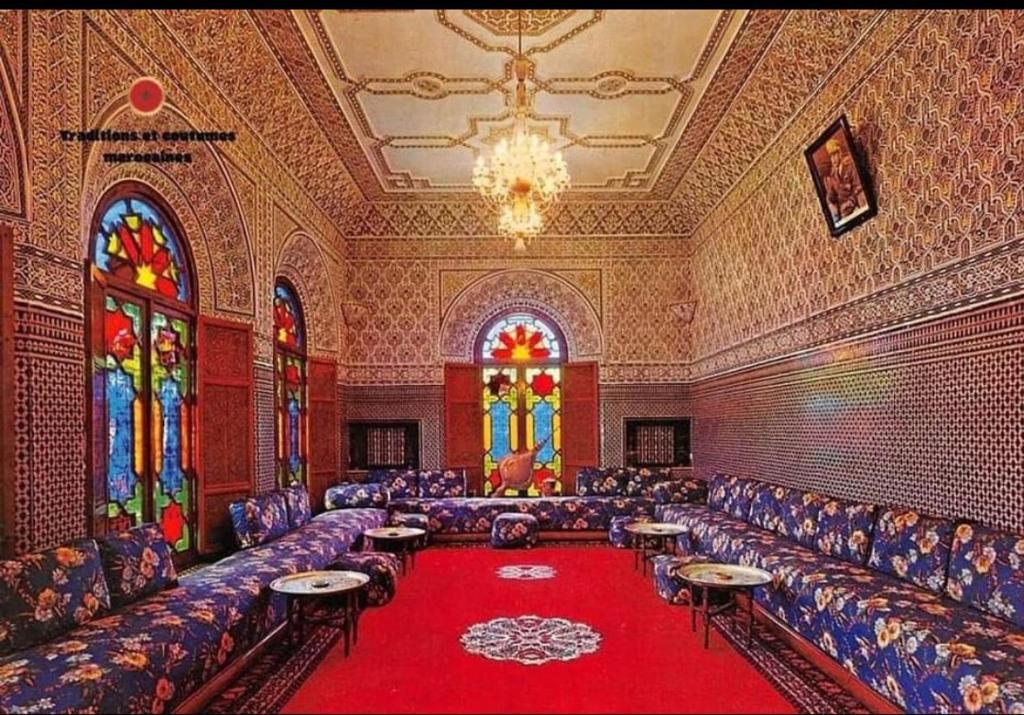 a large room with couches and a red carpet at Riad dar Ahlam in Aït Baha