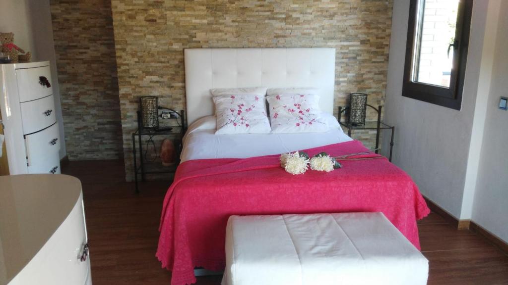 een slaapkamer met een groot bed en een roze deken bij Villa Alba cerca de Sitges in Canyelles