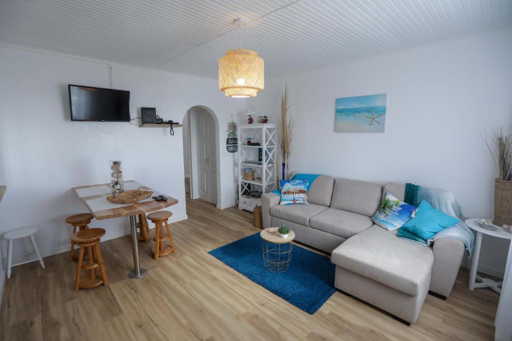 een woonkamer met een bank en een tafel bij Estrela do Atlântico in Ponta Delgada