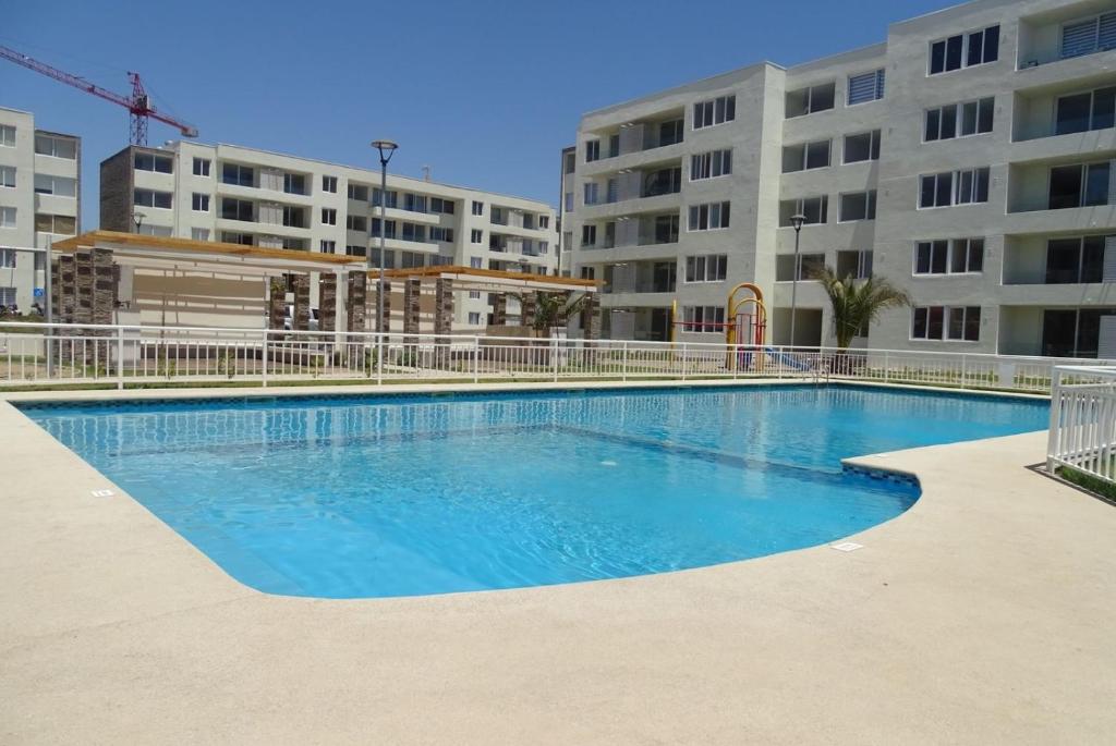 - une piscine en face d'un immeuble dans l'établissement Departamento Jardines del Pacifico, à La Serena