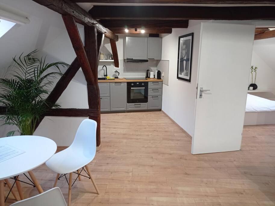 a kitchen with a table and two white chairs and a kitchen with a bed at Wohlfühl-Oase in der Altstadt in Delitzsch