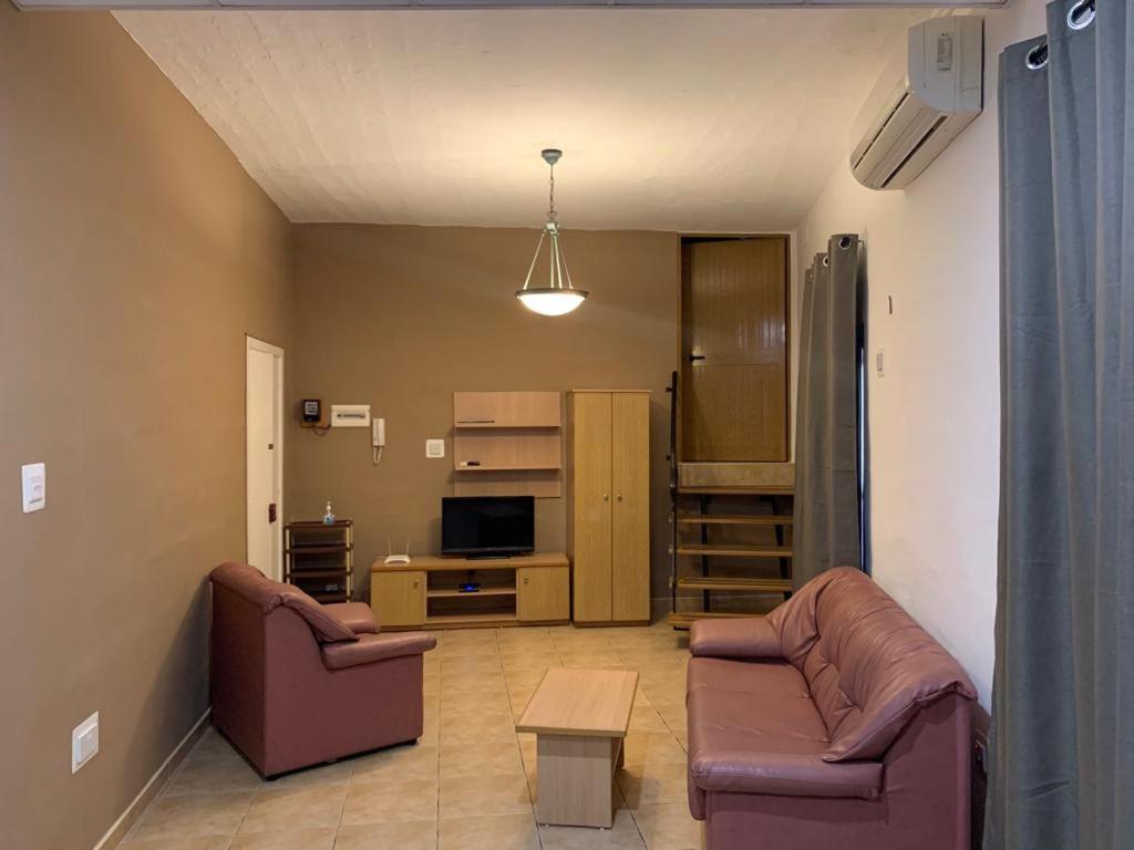 uma sala de estar com dois sofás e uma mesa em GELMIF Apartments em Vittoriosa